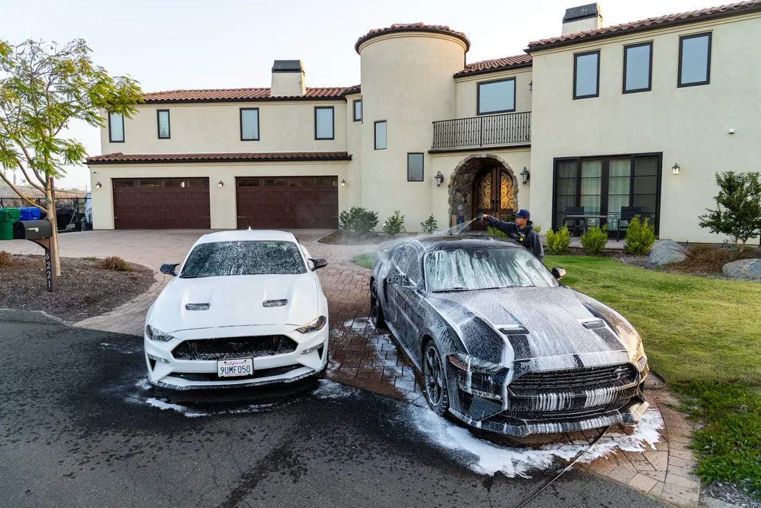 Two Mustangs getting an at-home mobile car wash